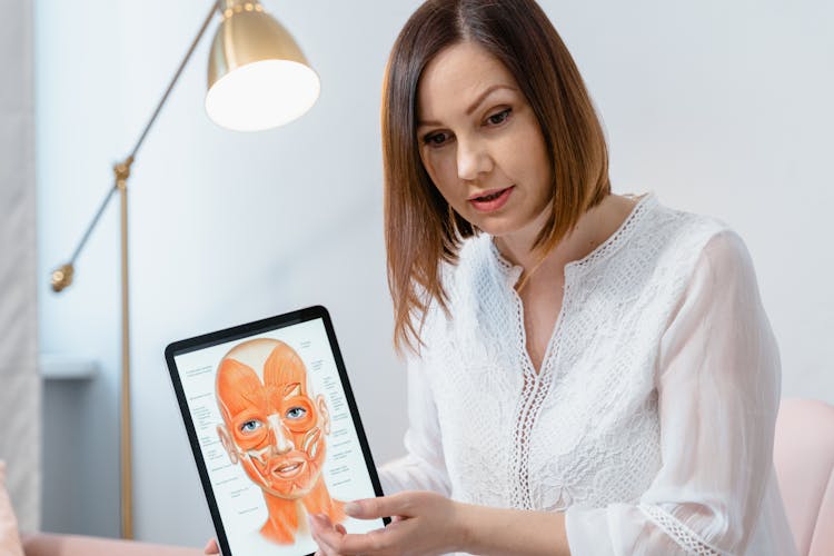 Close-up Photo Of An Aesthetician Holding An Ipad 