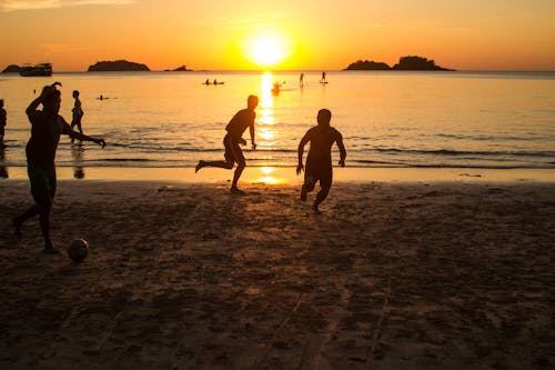 Free People playing Football on Beach Shore  Stock Photo