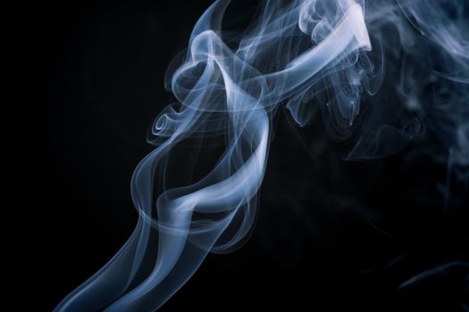 Ethereal smoke swirl forming abstract patterns against a dark backdrop.