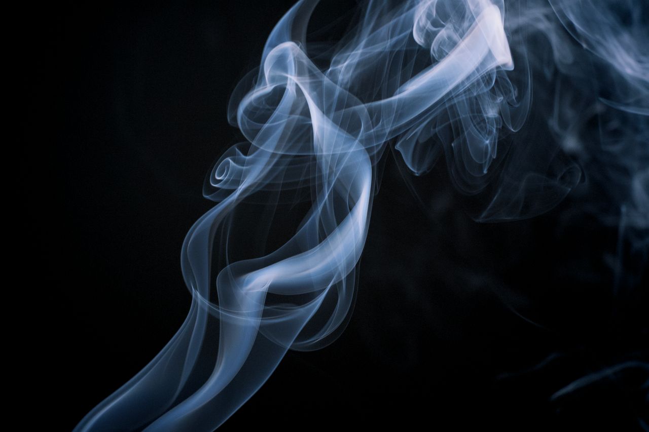 ethereal smoke swirl forming abstract patterns against a dark backdrop
