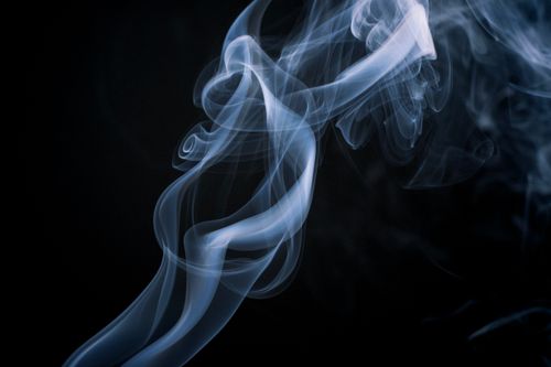 Free Ethereal smoke swirl forming abstract patterns against a dark backdrop. Stock Photo