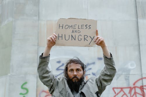 Free A Homeless Man Holding a Sign Stock Photo