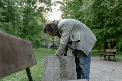 Free Homeless Man picking up Leftovers on a Trashbin  Stock Photo