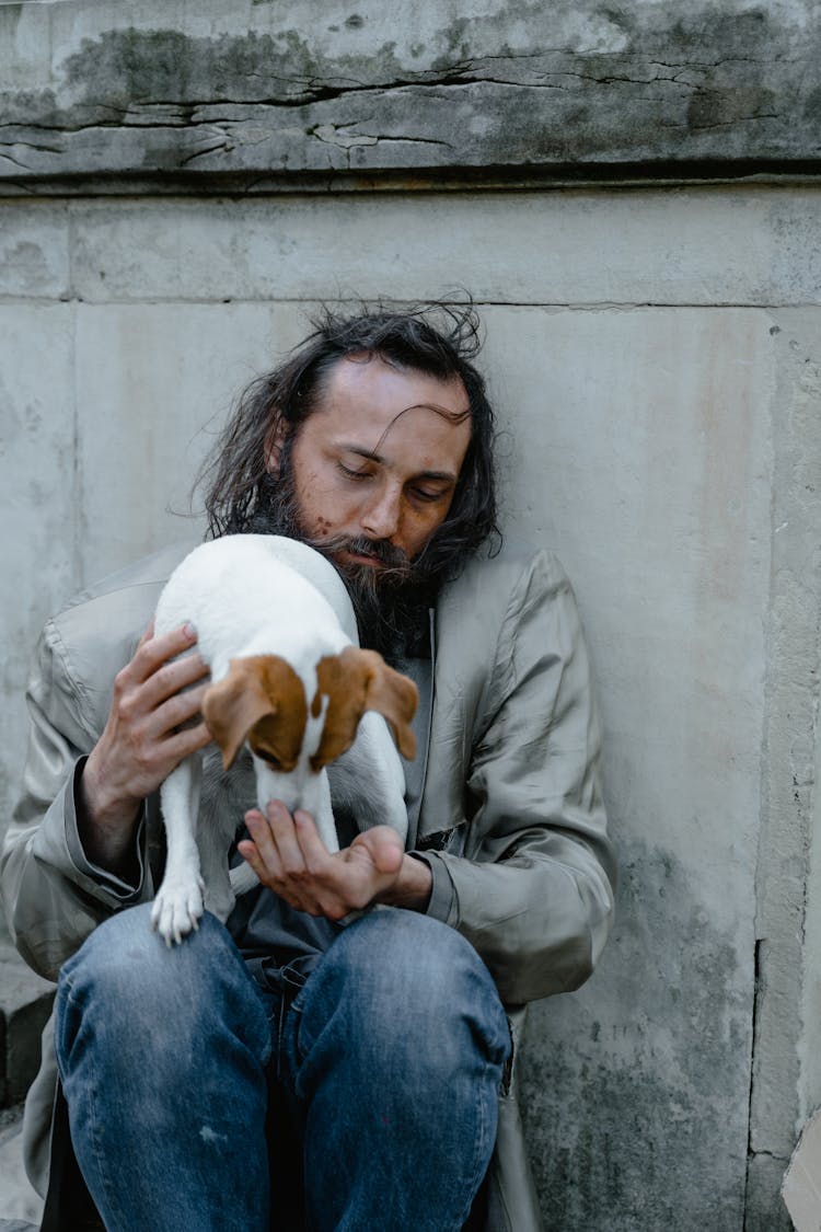 A Man Feeding A Dog To His Hand