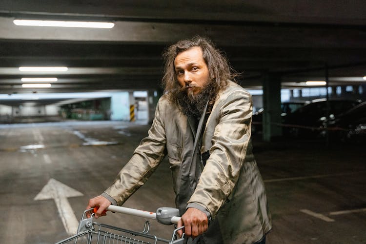 Man In Gray Coat Holding A Shopping Cart