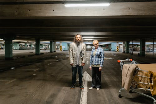 Free Man and Woman Standing at a Parking Lot Stock Photo