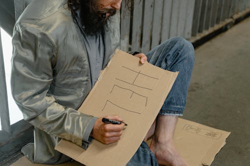 Person Writing on Cardboard 