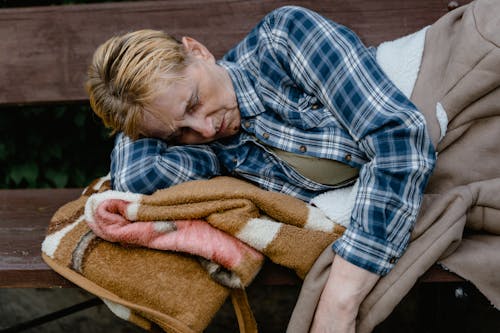 Free Homeless Elderly Woman sleeping on Wooden Bench  Stock Photo