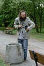 Woman in Gray Jacket and Blue Denim Jeans Standing on Gray Concrete Bench