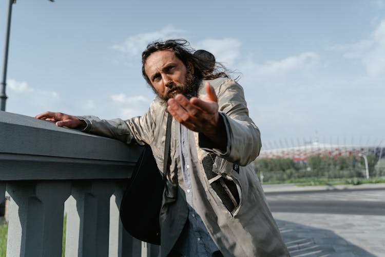 A Homeless Man In Gray Suit Begging