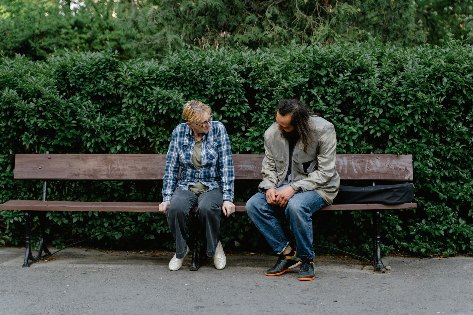 People sitting together on a wooden bench in conversation