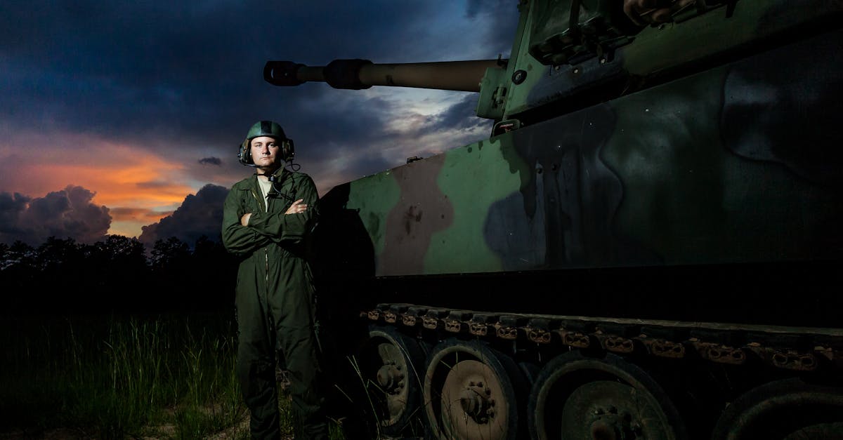 A Military Man Standing Besides a Tank