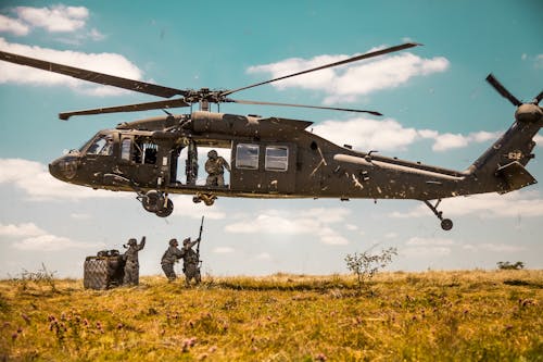 Free A Us Army Helicopter Hovering Above A Group of Soldiers Stock Photo