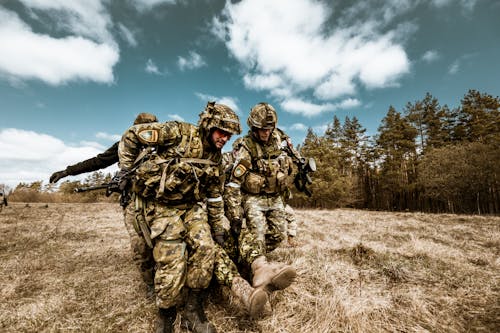 Free Soldiers in Action Saving a Brother Stock Photo
