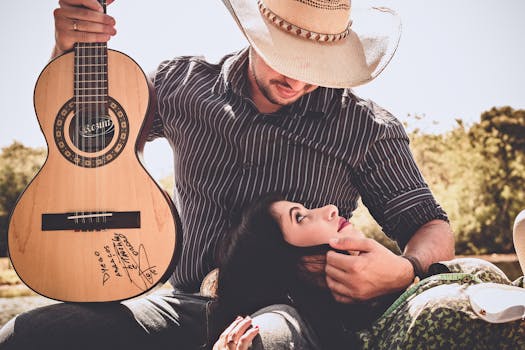 Woman In Green Top With Man In Black Long-sleeved Shirt Holding Autographed Brown Guitar