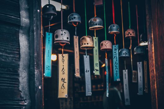 Colorful Japanese wind chimes hanging in a shop, showcasing traditional designs.
