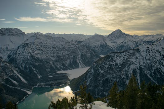 Scenic winter view of snowy mountain peaks and lake in Tirol, Austria.