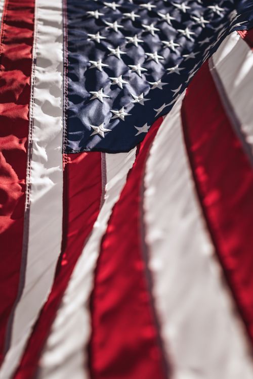 Free Detailed close-up of the American flag highlighting stars and stripes in soft light. Stock Photo