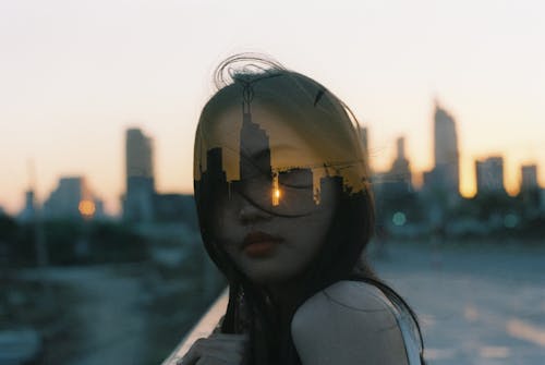 Free A Portrait of a Woman and a Skyline during the Golden Hour Stock Photo