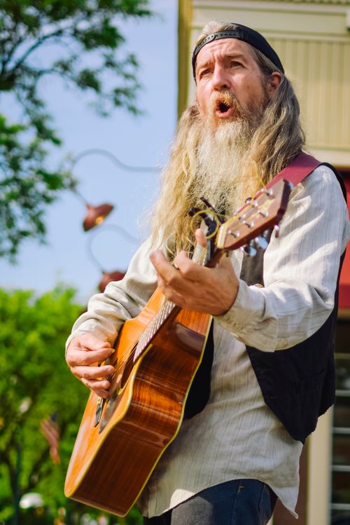Free Elderly bearded musician passionately plays acoustic guitar outdoors in a park. Stock Photo