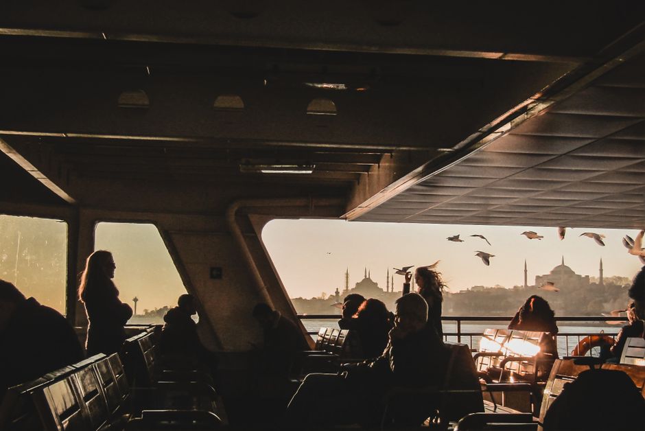Passengers enjoy a picturesque sunset ferry ride with views of Istanbul's skyline.