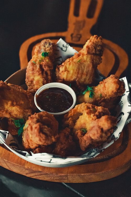 Free Delicious crispy fried chicken served with a tangy dipping sauce, beautifully presented in a rustic setting. Stock Photo
