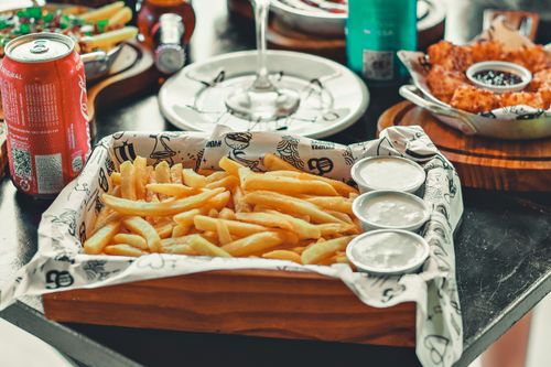 Free A tempting tray of french fries with dipping sauces served on a wooden tray, ideal for food reviews. Stock Photo