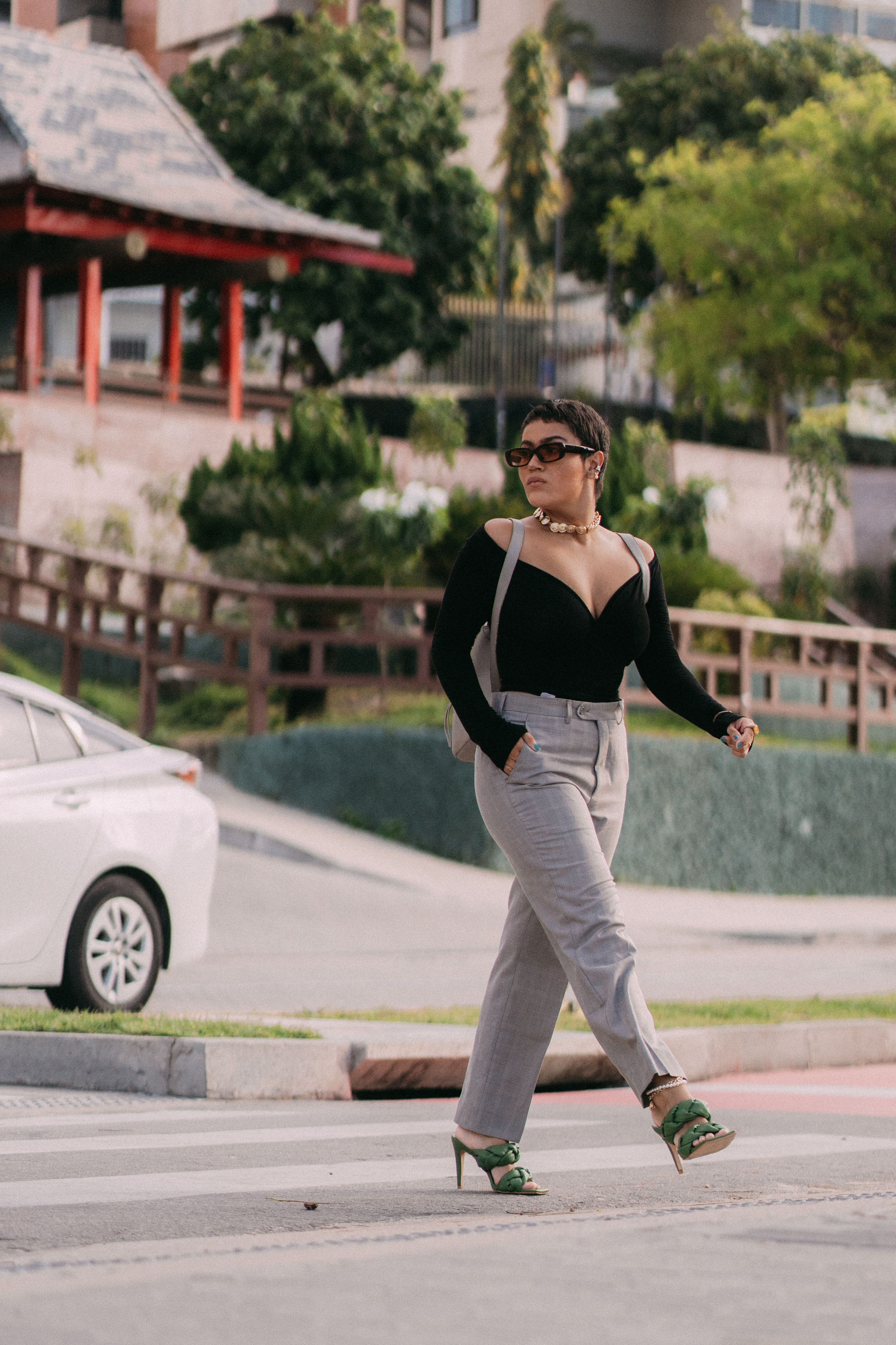 Mulher estilosa em ambiente urbano com óculos de sol, exibindo moda elegante.