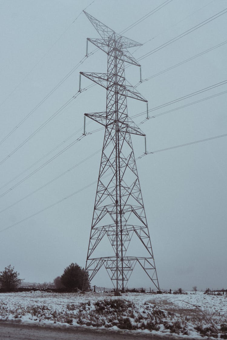 Tall Electricity Pylon In A Field At Winter 