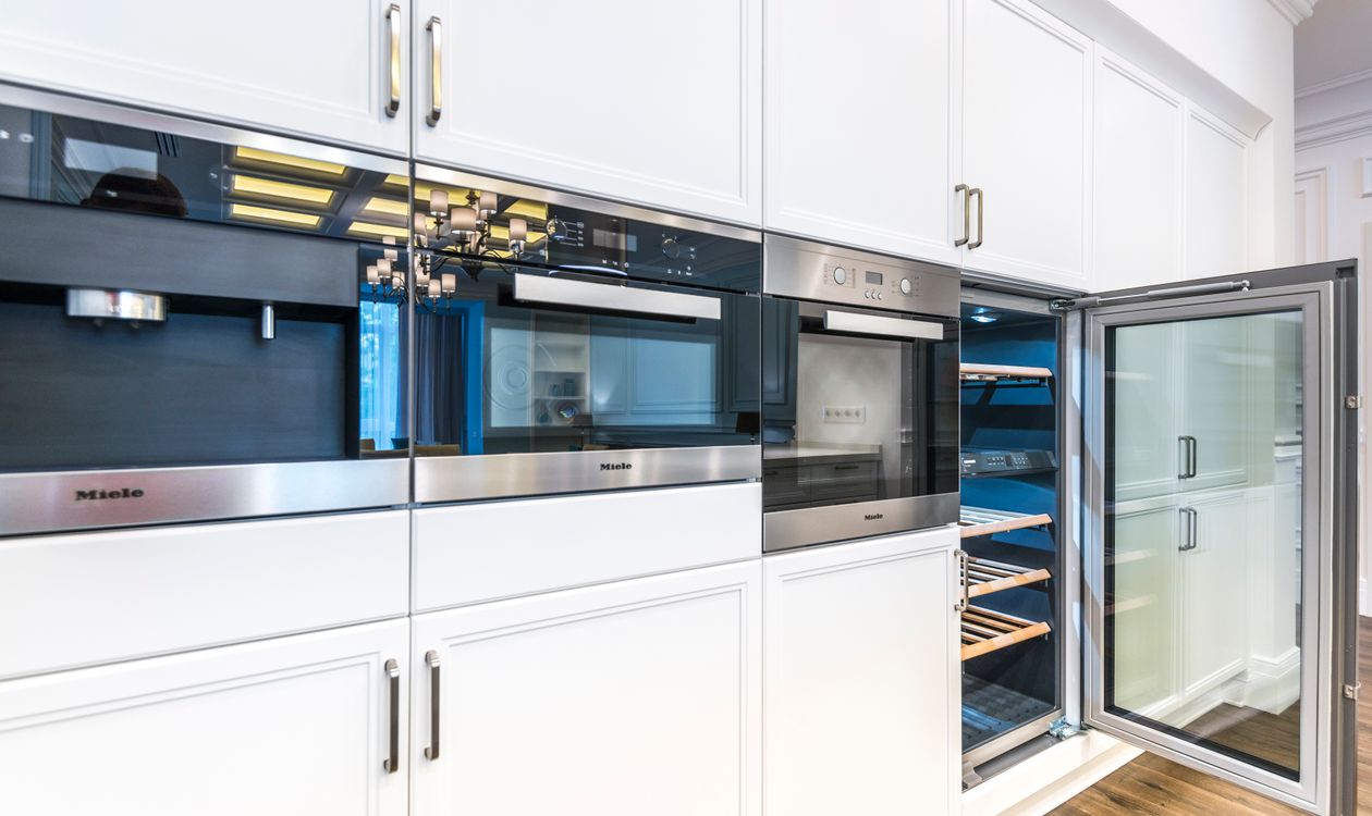 High-end built-in kitchen appliances in a luxury white kitchen