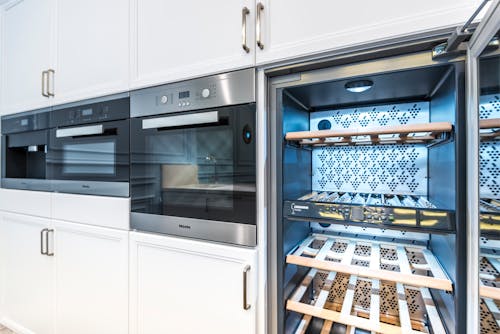 Free Elegant modern kitchen featuring built-in ovens and a wine cooler with stylish cabinetry. Stock Photo