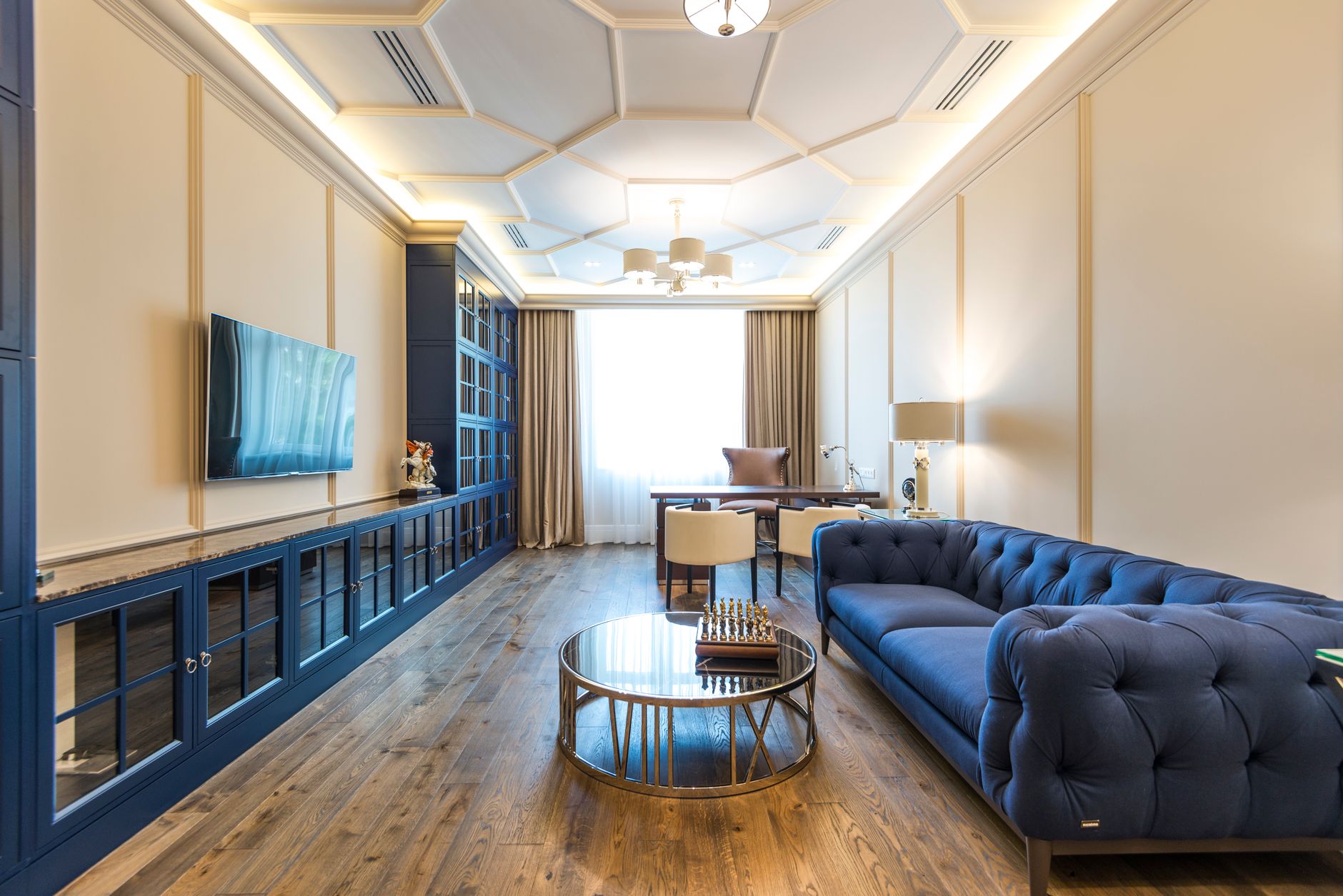 high end apartment design on a budget A luxurious apartment interior featuring a blue sofa, modern decor, and elegant lighting.