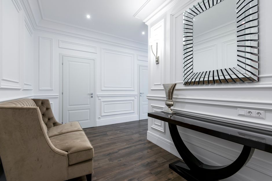 Luxurious hallway featuring a modern mirror, sophisticated sofa, and sleek decor, ideal for real estate and interior design inspiration.