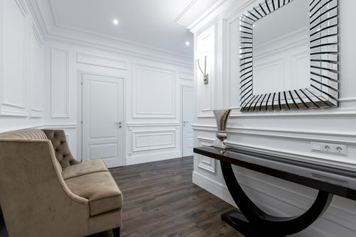 Free Luxurious hallway featuring a modern mirror, sophisticated sofa, and sleek decor, ideal for real estate and interior design inspiration. Stock Photo