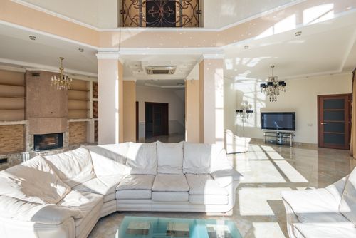 Free Spacious luxury living room with modern decor, sectional sofa, chandeliers, and TV. Stock Photo