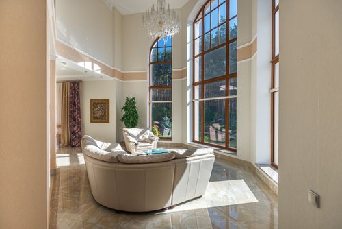 Free Spacious modern living room featuring large windows, elegant design, and luxurious furnishings. Stock Photo