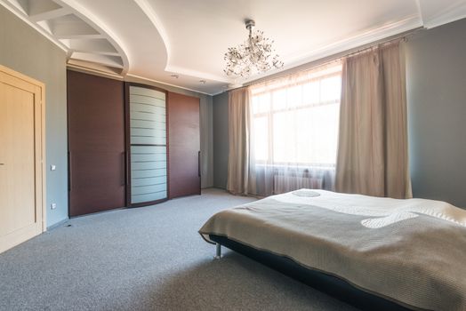A spacious, modern bedroom with elegant design elements and ample light.