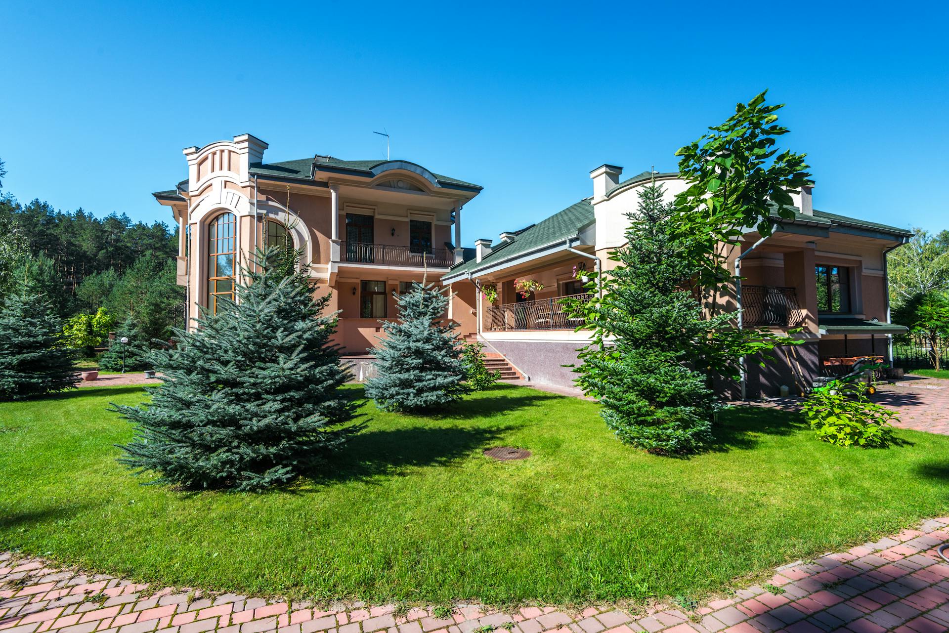 Elegant suburban estate with modern architecture amidst lush greenery, captured on a sunny day.