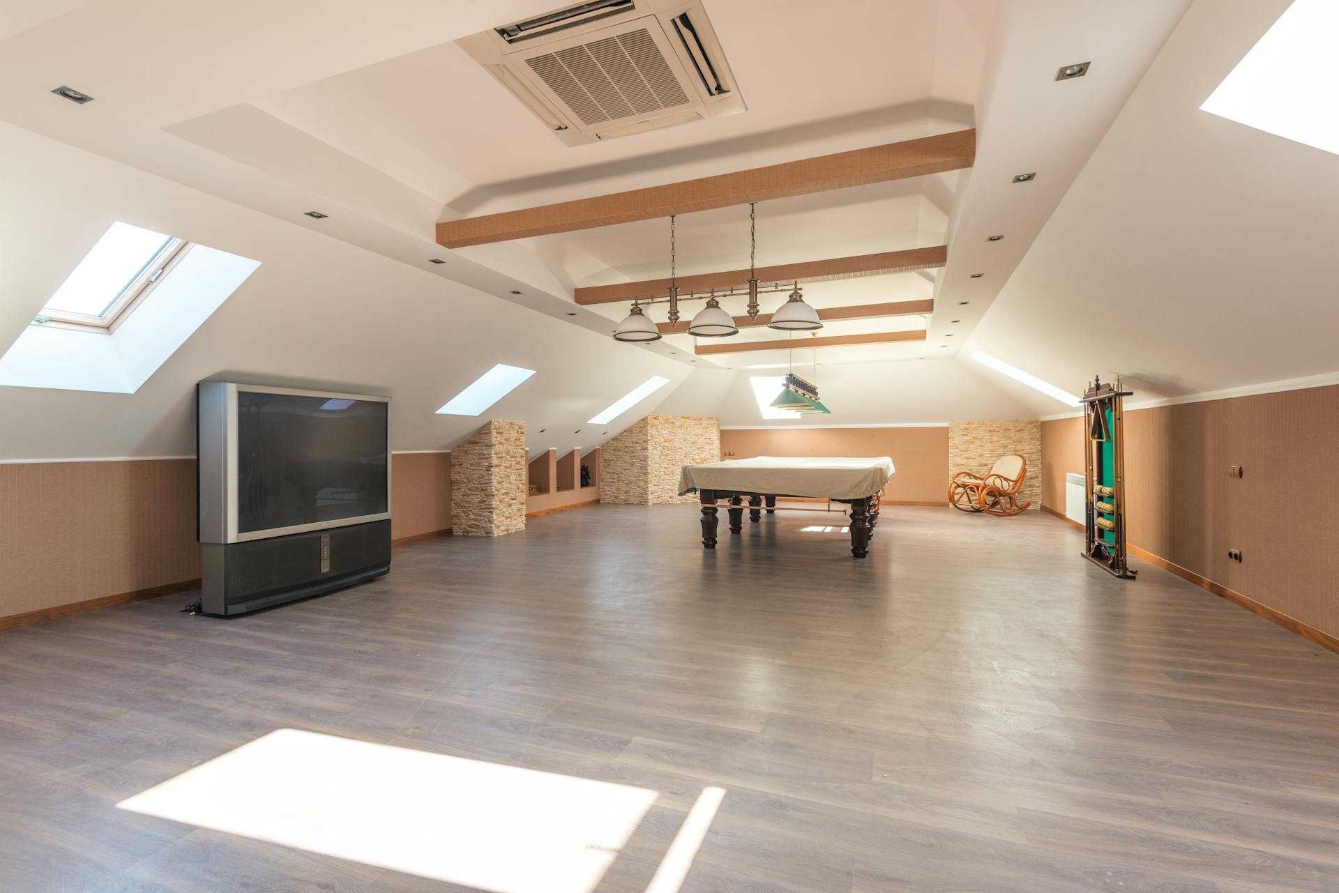 Bright attic space featuring a sleek pool table and skylights, perfect for leisure.