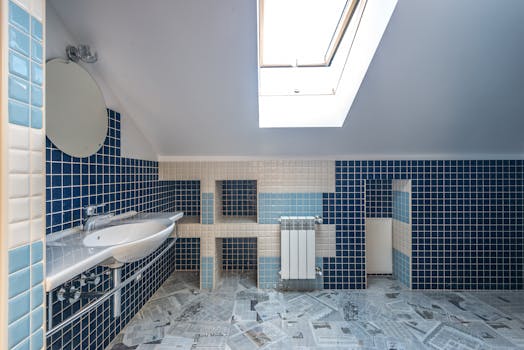 A clean, spacious bathroom with blue and white tiles, featuring a wash basin and skylight.