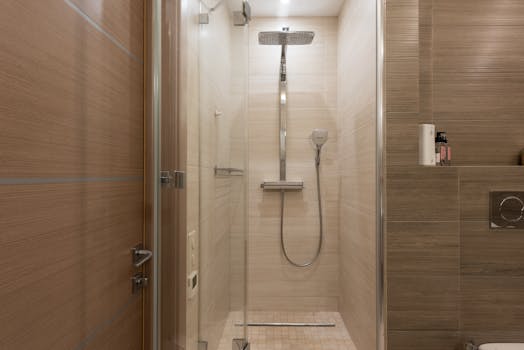 Sleek modern shower with glass door in a contemporary bathroom setting, featuring elegant interior design.