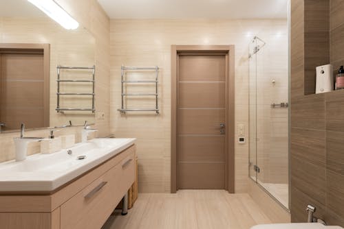 Interior of a Luxury Bathroom with Glass Shower Cabin in Beige Tone