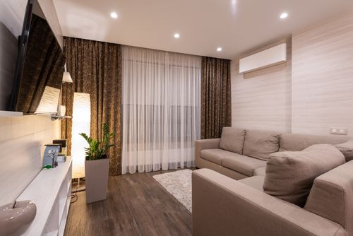 Free A stylish and cozy living room featuring a sofa, wooden flooring, and soft lighting. Stock Photo