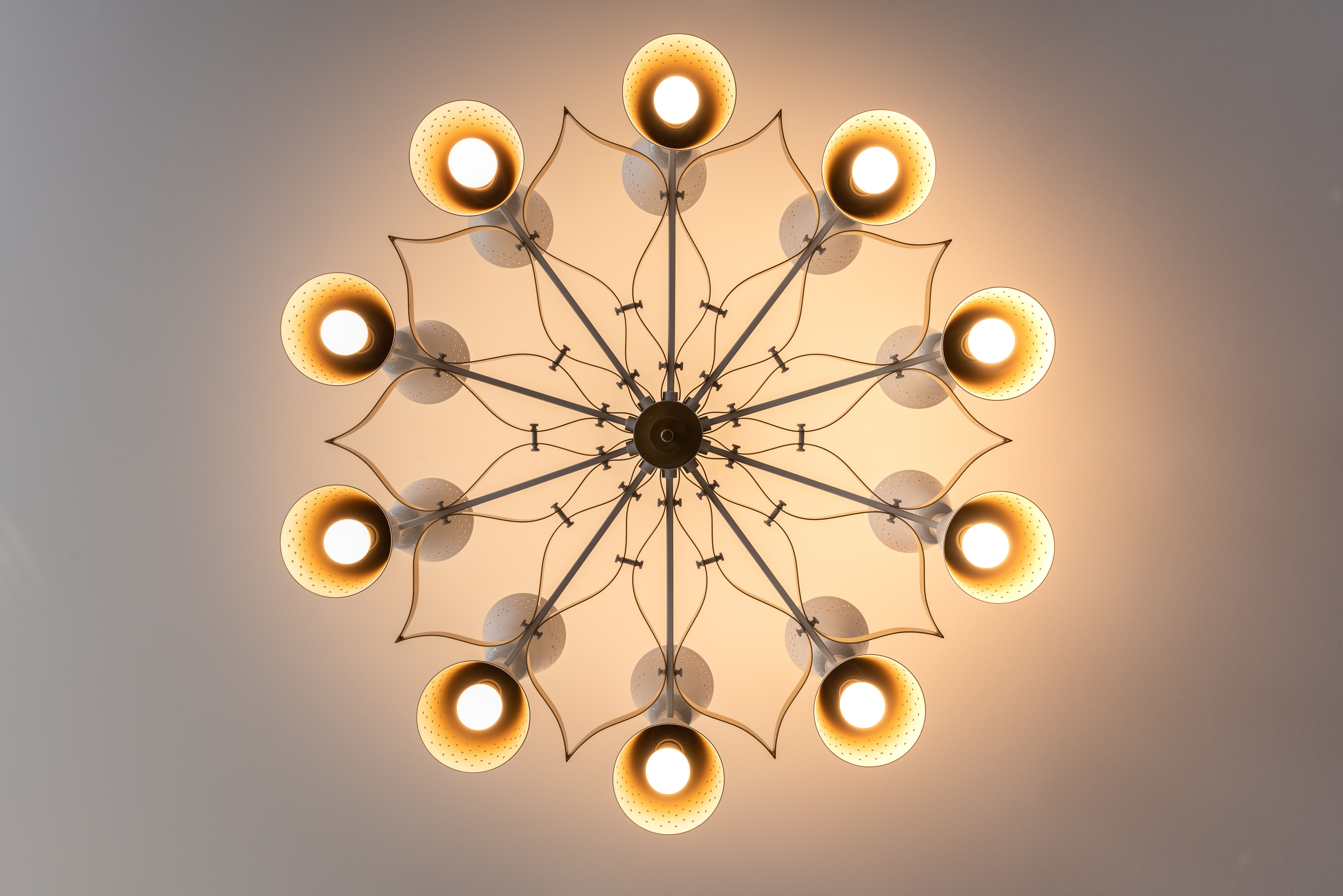 A stylish modern chandelier emitting warm light, viewed from below, perfect for interior design inspiration.