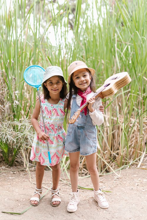 Free Little Girls in Panama Hats Standing near High Grass Stock Photo