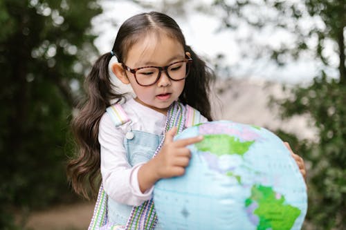 A Girl Pointing on a Globe