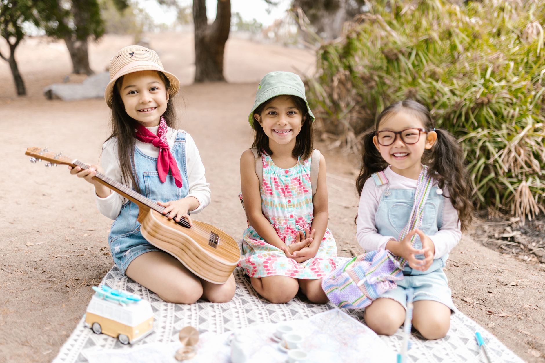 summer funday sahel — Three smiling girls enjoying a cheerful picnic on a sunny day outdoors.