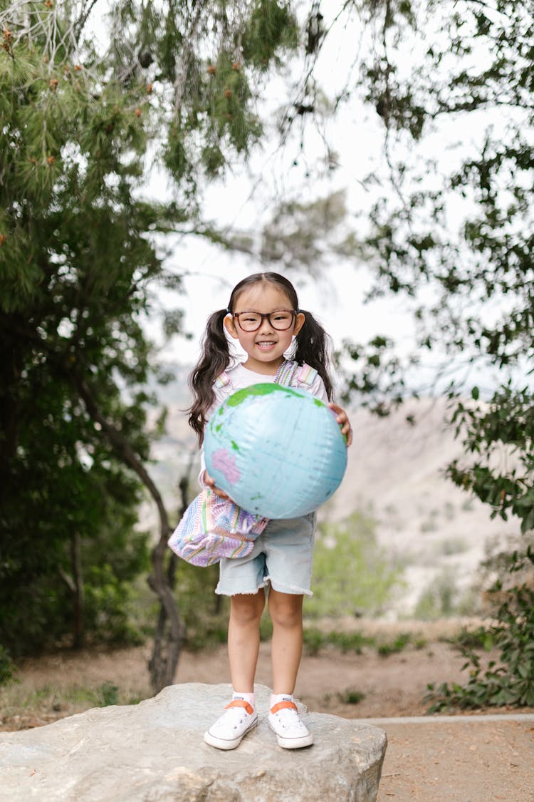 A Girl Holding A Globe