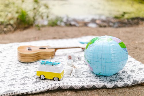 Globe and a Guitar on a Picnic Blanket