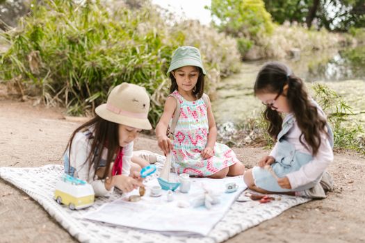 2 Girls Sitting on White Mat on Brown Sand